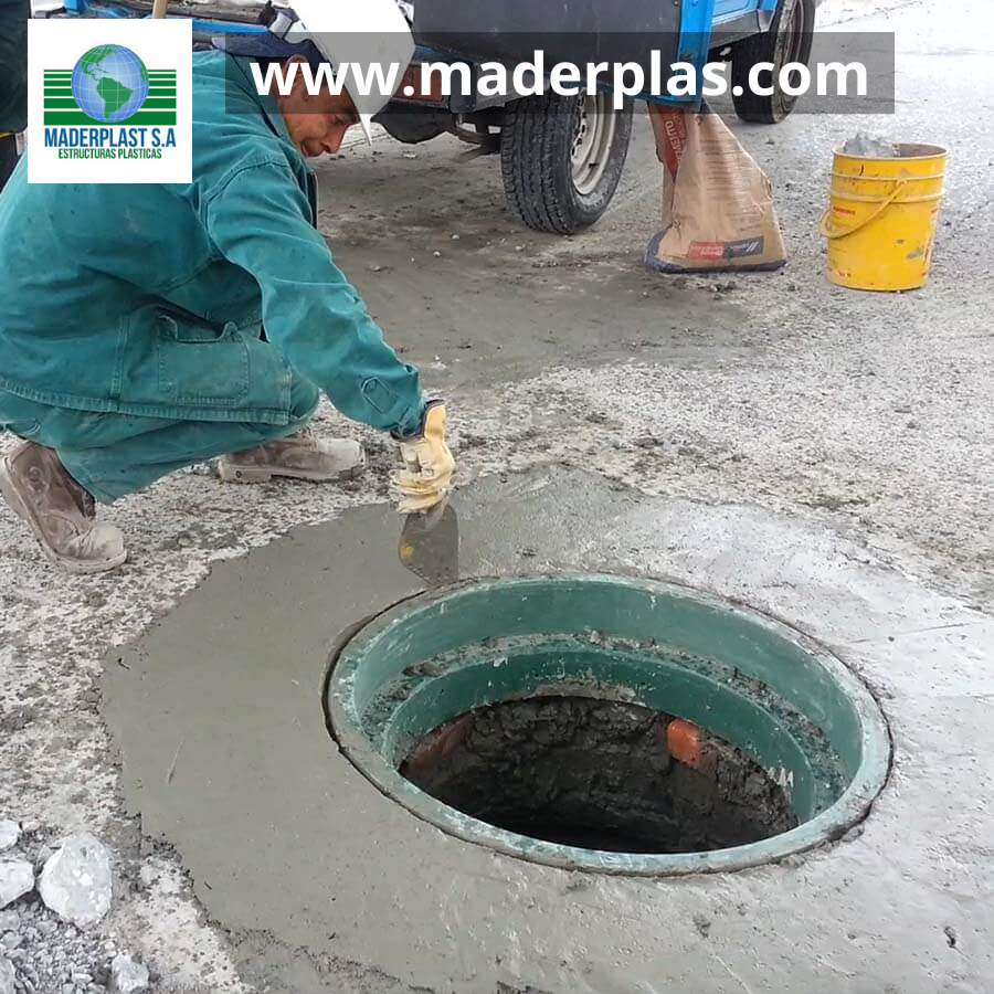 Acabado con mortero alrededor del aro base plástico Maderplast para tapa de pozo de inspección durante su instalación en una vía urbana.