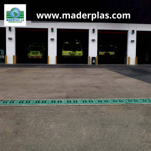 Rejilla plástica lineal de polipropileno Maderplast instalada en el acceso vehicular de una estación de bomberos para el drenaje eficiente de aguas lluvias.