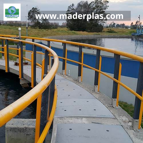 Barandas plásticas anticorrosivas Maderplast instaladas en una pasarela curva de una planta de tratamiento de agua, diseñadas para brindar seguridad y resistencia en ambientes industriales.