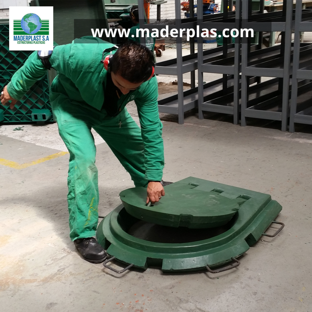 Operario levantando una tapa plástica para caja de inspección Maderplast con sistema de apertura ergonómica y marco reforzado, ideal para redes de alcantarillado, servicios públicos e infraestructura industrial.