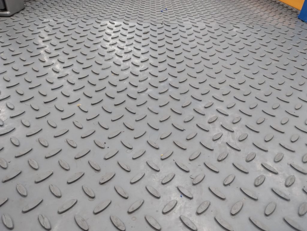 Pisos de alfajor en polipropileno Maderplast color gris claro, superficie antideslizante, modular y resistente a humedad, químicos e impactos para áreas de alto tránsito industrial y comercial.