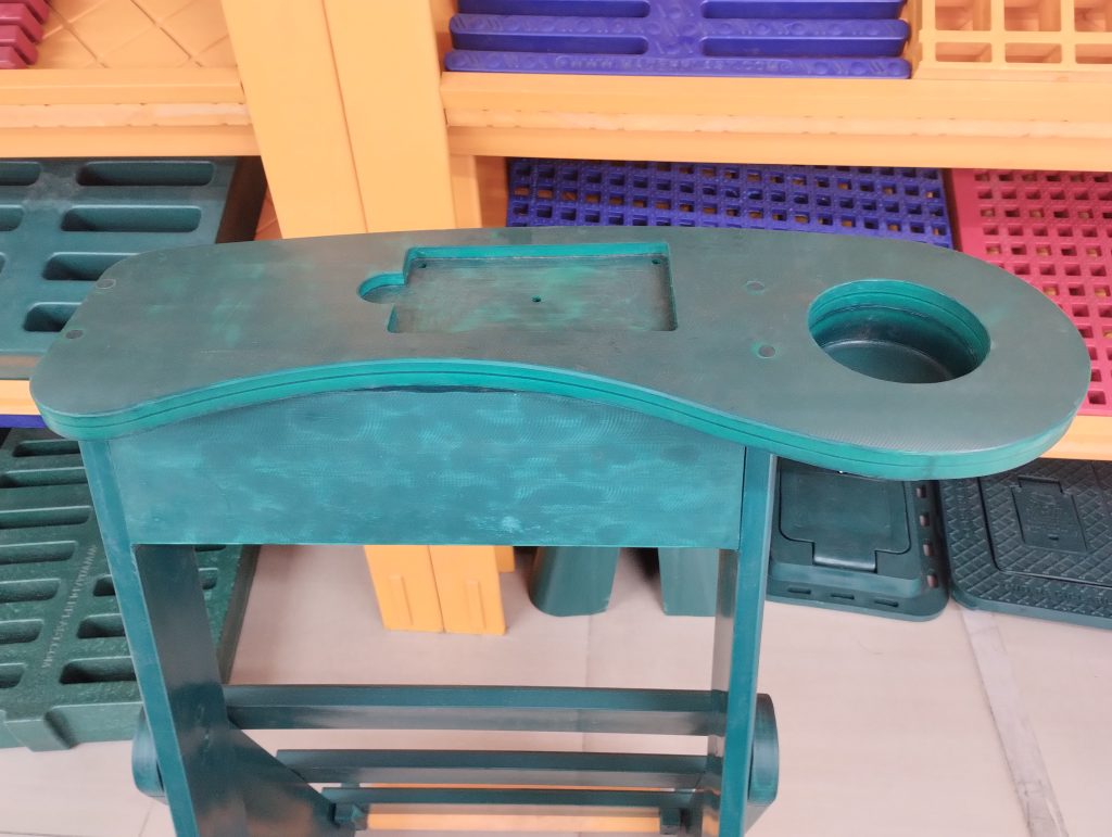 Vista superior de soporte para palos de golf en polipropileno verde con bandeja y porta vasos Maderplast.