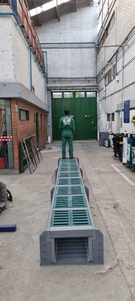 Trabajador sobre canaleta prefabricada en polipropileno instalada en área industrial de Maderplast.