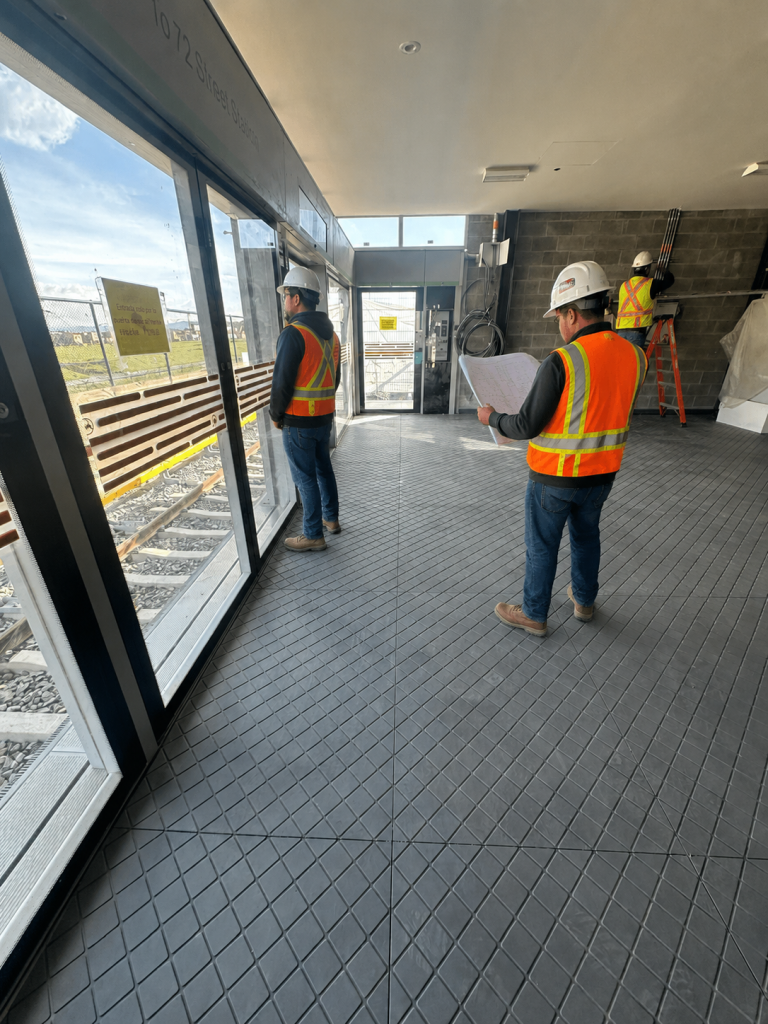 Piso técnico dieléctrico Maderplast en estación ferroviaria, fabricado en polipropileno de alto impacto, resistente al agua, humedad, rayos UV y productos químicos para tránsito peatonal industrial de alta intensidad.